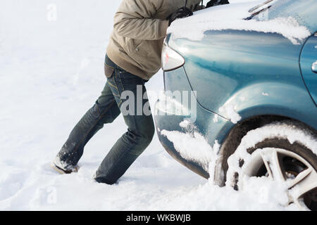 Libre de l'homme coincé dans la neige voiture poussant Banque D'Images