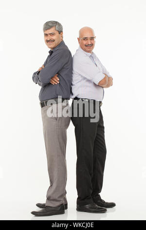 Two business executives standing back to back with his arms crossed Stock Photo