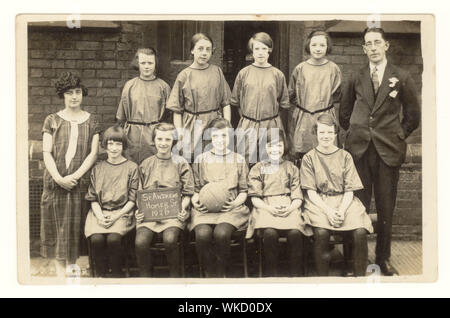 Début des années 1900 Carte postale de l'équipe de netball de la jeune fille, souriant et heureux, à l'école de Saint-André, Homer Street, Manchester, Angleterre, Royaume-Uni en date du 1926 Banque D'Images