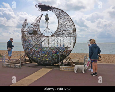 Les visiteurs qui cherchent à mettre en évidence une sculpture déchets plastiques sur la promenade de Southsea, Hampshire, Angleterre. Banque D'Images