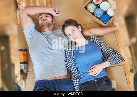 Jeune couple se détend dans une pause pendant la rénovation dans leur nouvelle maison Banque D'Images
