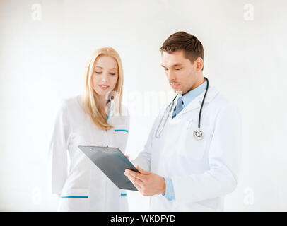 Concept de la santé - smiling young male doctor with stethoscope et presse-papiers et l'infirmière à l'hôpital Banque D'Images