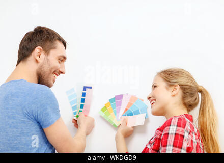 La réparation, le design intérieur, la construction, la rénovation et l'accueil concept - smiling couple looking at échantillons de couleur à la maison Banque D'Images