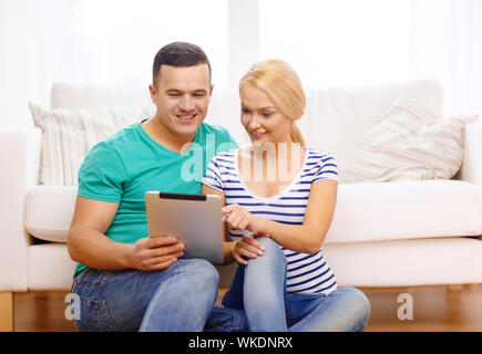 L'amour, la famille, la technologie, internet et le bonheur concept - smiling couple heureux witl tablet pc ordinateur à domicile Banque D'Images