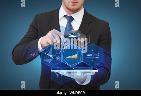 Businessman hand holding loupe sur tablet pc Banque D'Images