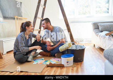 Jeune couple à se parler dans une atmosphère détendue casser lors d'un déménagement ou la rénovation Banque D'Images