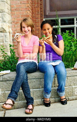 Deux adolescentes assis et eating pizza Banque D'Images