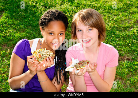 Deux adolescentes assis et eating pizza Banque D'Images