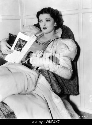 MYRNA LOY que Nora Charles dans APRÈS L'HOMME MINCE 1936 franc sur le plateau du tournage de la lecture du magazine The New Yorker directeur W. S. Van Dyke et cinématographe OLIVER T. MARSH story Dashiell Hammett armoire DOLLY TREE Metro Goldwyn Mayer Banque D'Images