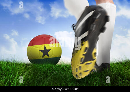 Image composite des coups de chaussure de football ghana ball contre un champ d'herbe sous ciel bleu Banque D'Images