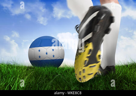 Image composite des coups de chaussure de football united states ball contre un champ d'herbe sous ciel bleu Banque D'Images