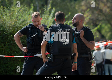 Berlin, Allemagne. 08Th Sep 2019. Les policiers sont debout près d'une maison à l'Bruno-Taut-Ring dans Neukölln. Un homme de 40 ans a été attaqué et il y a des blessures mortelles. L'homme était gorgé de sang trouvés le mercredi matin en face d'une maison sur l'anneau de Bruno Taut et est mort un peu plus tard à l'hôpital, la police a déclaré. Crédit : Paul Zinken/dpa/Alamy Live News Banque D'Images