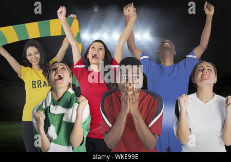 Image composite de plusieurs fans de football contre terrain de football sous les projecteurs Banque D'Images