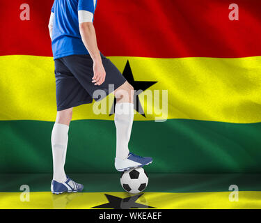 Image composite du joueur de football debout avec balle contre générés numériquement drapeau national du Ghana Banque D'Images