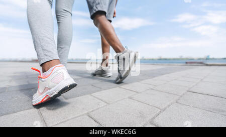 Couple Afro méconnaissable jambes le long River Embankment, récolte Banque D'Images