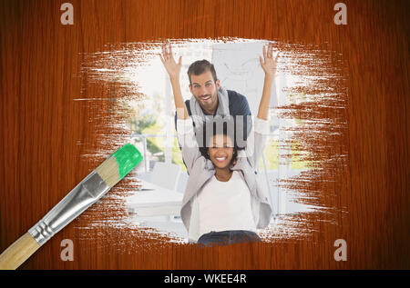 Image composite de collègues ayant l'amusement avec le pinceau trempé dans du bois vert contre table en chêne Banque D'Images