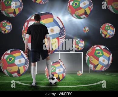 Image composite du joueur de football sur le point de prendre une sanction contre un terrain de football sous les projecteurs Banque D'Images