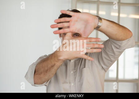 Businessman ossature bois avec ses mains dans son bureau Banque D'Images