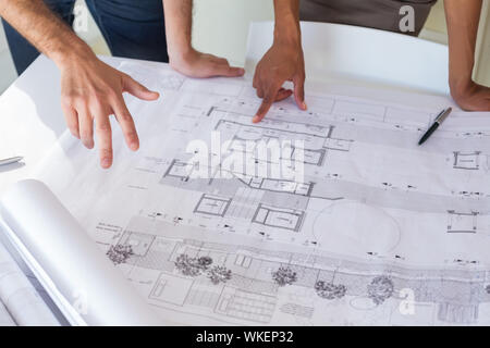 Workers looking at blueprints important dans le bureau Banque D'Images