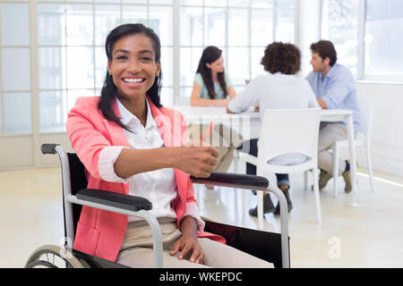 Attractive businesswoman in Thumbs up donne à l'appareil photo au bureau Banque D'Images