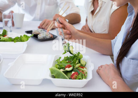 Les personnes bénéficiant d'affaires salade et salade pour le déjeuner au bureau Banque D'Images