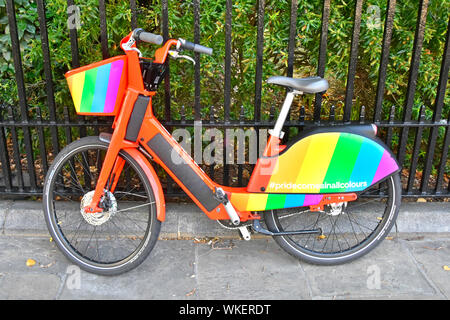 Location colorés dans Gay Pride drapeau arc-en-ciel de couleurs sur un GPS tracker app Uber pédale électrique vélo garé à côté de Jump aider Londres Angleterre Royaume-uni garde-corps Banque D'Images