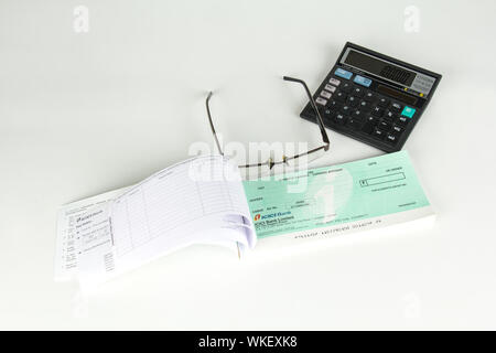 Vue en grand angle d'un livre de chèques vide avec calculatrice et lunettes Banque D'Images