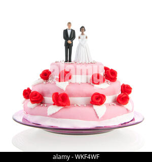 Couple mixte sur le dessus de gâteau de mariage rose avec roses rouges isolated over white background Banque D'Images