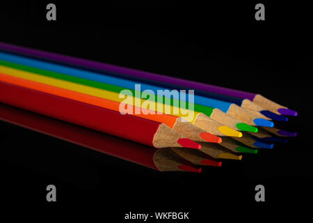 Groupe de 6 ensemble de crayons de couleur couleurs arc-en-ciel isolé sur verre noir Banque D'Images