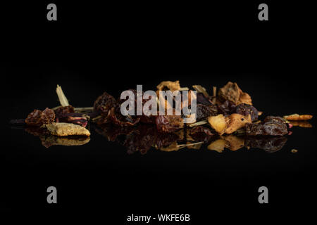 Beaucoup de morceaux de fraises airelles plateau heap isolé sur verre noir Banque D'Images