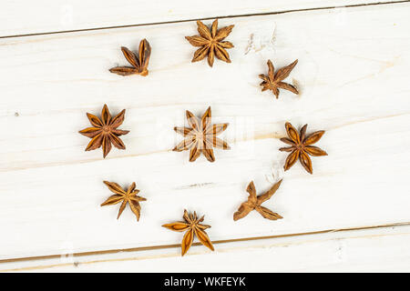 Beaucoup d'ensemble brun sec badiane illicium verum flatlay sur bois blanc Banque D'Images