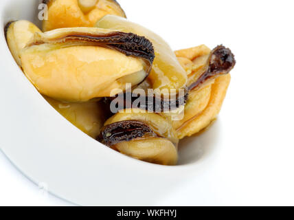 Moules fumées de collation avec de l'huile d'olive dans un bol blanc isolé sur fond blanc Banque D'Images