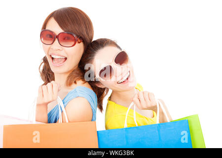 Les jeunes sœurs holding shopping bags et dos à dos Banque D'Images