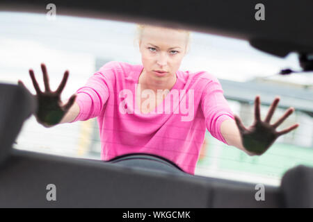 Auto-suffisant, strong, jeune femme poussant une voiture. Panne moteur. Banque D'Images