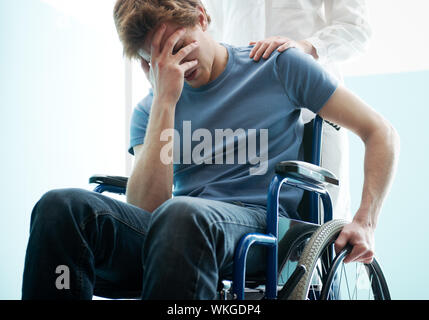 Femme médecin triste consolation man sitting in wheelchair Banque D'Images
