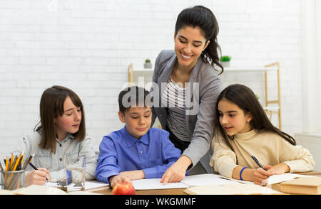 Aider les enfants d'enseignants en classe, à faire leurs devoirs ensemble Banque D'Images