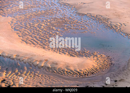 L'eau et des modèles dans le sable au coucher du soleil, Mawgan Porth Beach à Cornwall, UK Banque D'Images