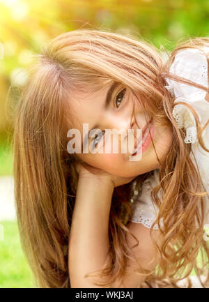 Closeup portrait of douce petite enfant extérieur, jolie fille arabe chaude journée d'été ensoleillée jouissant, heureux et insouciant du concept de la petite enfance Banque D'Images