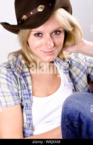 Jolie femme occidentale en chemise de cowboy hat et isolé sur fond blanc Banque D'Images