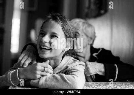 Tresses tresses dans les cheveux de grand-mère à petite fille drôle. Photo en noir et blanc. Banque D'Images