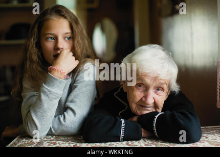 Portrait d'une vieille femme aux cheveux gris avec sa petite-fille. Banque D'Images