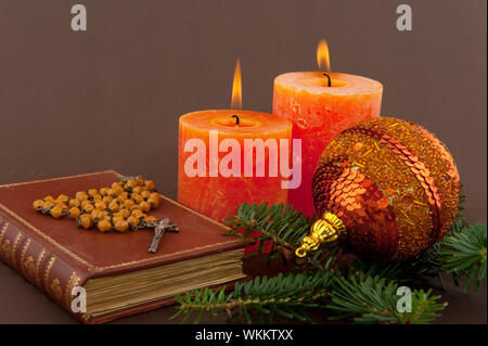 Bougie de Noël et de bible avec rosaire sur marron Banque D'Images