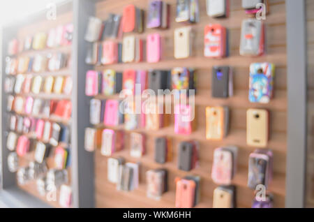 Arrière-plan flou de cas de téléphone en vente sur le mur d'une boutique. Banque D'Images