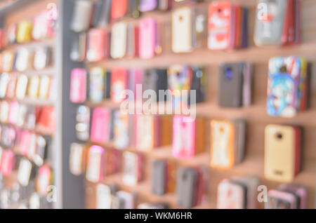 Arrière-plan flou de cas de téléphone en vente sur le mur d'une boutique. Banque D'Images