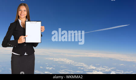 Businesswoman holding porte-papier. Plus de trace de l'avion les nuages en toile Banque D'Images