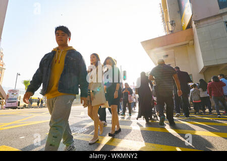 HONG KONG, CHINE - circa 2019, février : une diversité de personnes traversant street à Hong Kong. Banque D'Images