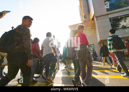 HONG KONG, CHINE - circa 2019, février : une diversité de personnes traversant street à Hong Kong. Banque D'Images