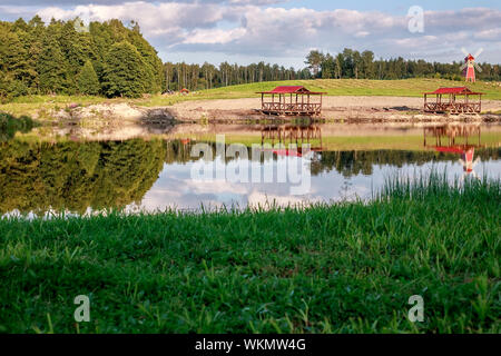 Zone de détente. L'eau bleu du lac dans une forêt de pins. La forêt se reflète dans l'eau. Bélarus Banque D'Images