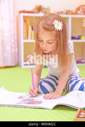 Jolie petite fille assise sur le sol et le dessin photo à l'album, s'amusant à la maison, enfance heureuse, avoir le talent de l'art concept Banque D'Images