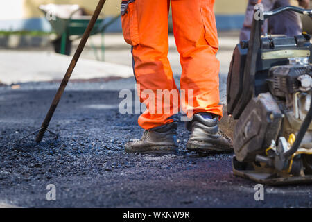 Revêtement bitumineux sur le travail manuel. Banque D'Images